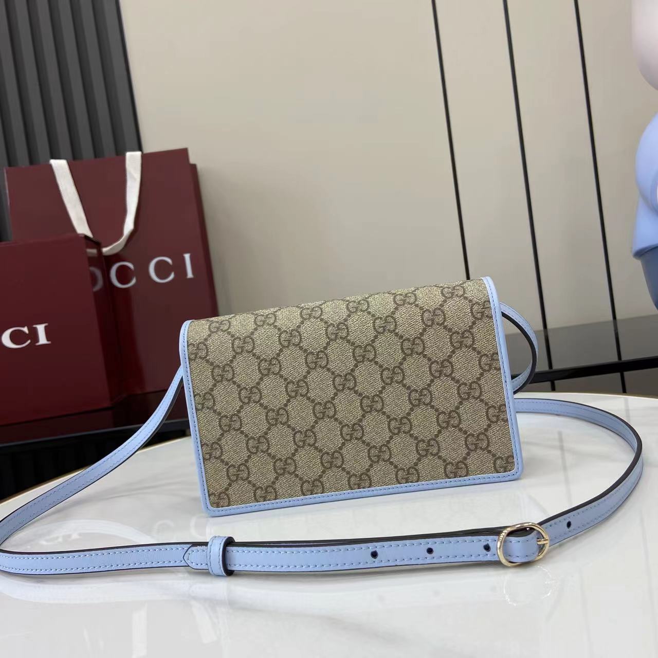 Gucci GG Emblem wallet with leather strap